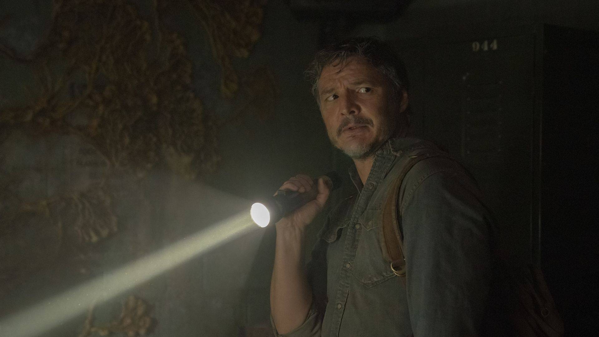 Joel segurando uma lanterna na mão direita